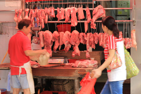 Butcher with a customer in Shau Kei Wan market, Hong Kongのeditorial素材