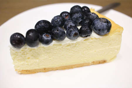 a blue berry cheese cake on wood background