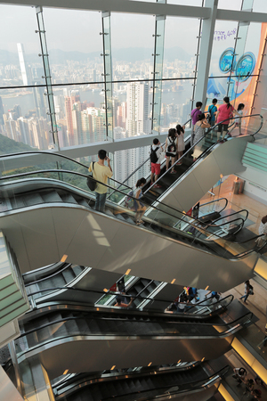 People riding on escalators in a busy shopping mall in Hong Kongのeditorial素材