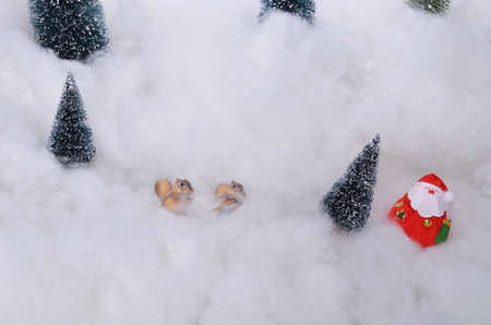 Reindeer ornamental figure with Christmas trees and snowの写真素材