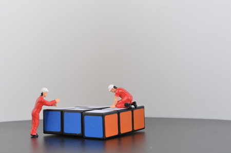 the Miniature workmen laying construction bricks work