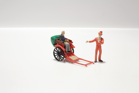 the Miniature statue and red vintage oriental rickshaw cabの写真素材