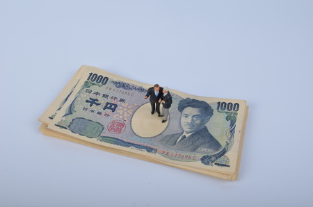 the Tiny person standing on a huge of moneyの写真素材
