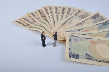 the Tiny person standing on a huge of moneyの写真素材