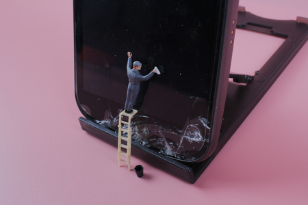 the Miniature people cleaning the mobile phoneのeditorial素材