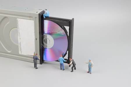 Selective focus of miniature engineer and worker fixed  CD rom