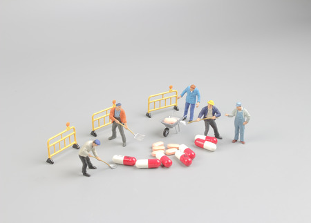 the worker figure in front of the pillsの写真素材