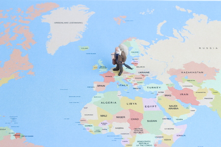 the Mini figurine of  lonely  traveler walking on map