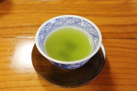 Green tea in a white cup on a ood  back groundの写真素材