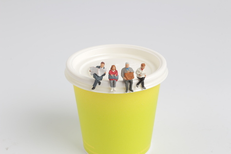 mini figure sitting and read on the paper cupの写真素材