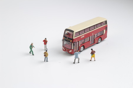 the group of figure taking photo with bus