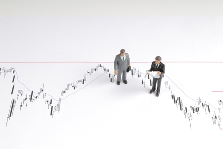 figure look skeptically on graph with stock pricesの写真素材