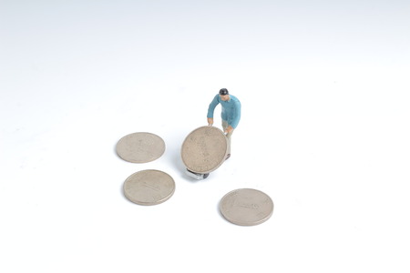 the Worker mini people figure pulling silver coinの写真素材