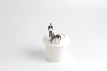 Mini people reading and sitting oncupの写真素材