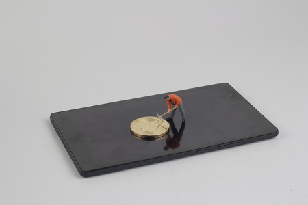 digging Mining Golden bitcoins on keyboard の写真素材