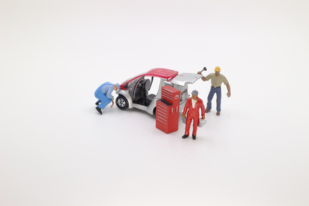 a mini mechanics figure working on a carの写真素材