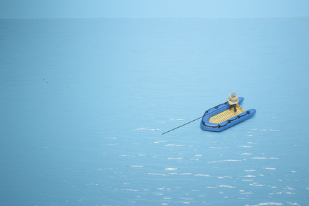 figure fisherman catching a fish boatの写真素材