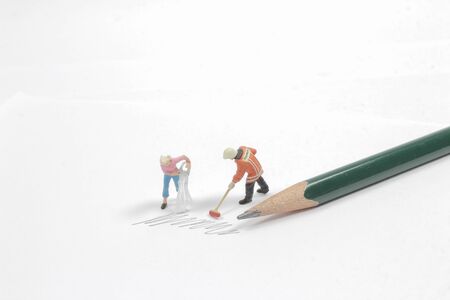 mini figure clear the pencil writing on paperの写真素材