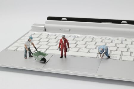 the mini figure owrk at the computer keyboardの写真素材