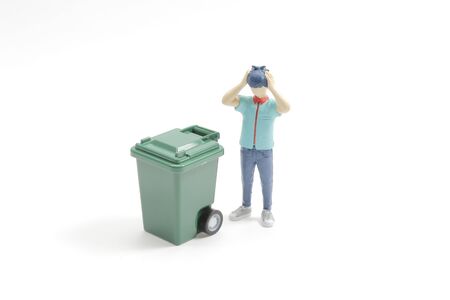 taking out the garbage from the rubbish container looking stressed の写真素材