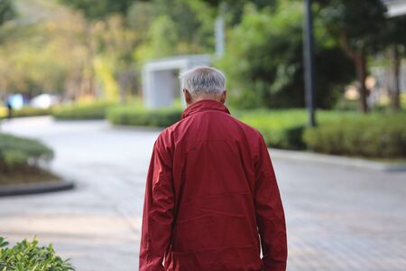 old man wear red jacket at parkの写真素材