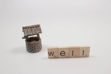 The scale of wish well with a few coins.の写真素材