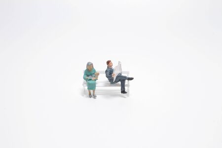 the mini figure  in a park sits on a benchの写真素材