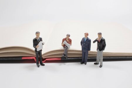 mini people standing with fountain pen on paper with white background.の写真素材