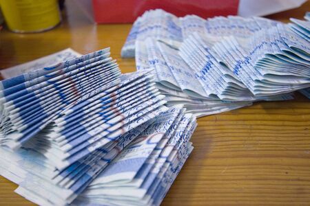 a Pile Of Notes ,  lying on the wooden table.