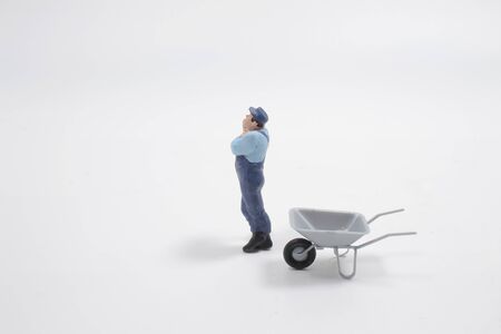 a mini people worker holding tool on white background,construction conceptの写真素材