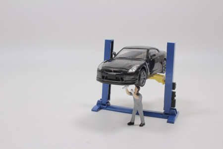 a Mini figure mechanic repairing dusty carの写真素材