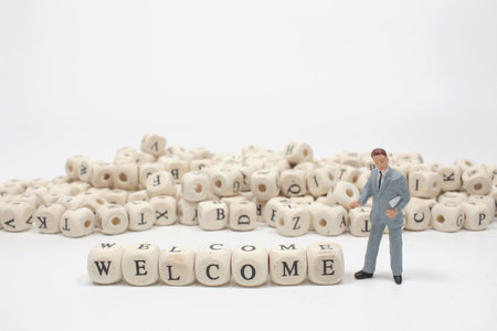 The word welcome on wooden cube block with figureの写真素材