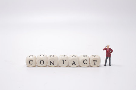 the figure talking mobile with the contact wood text cubeの写真素材