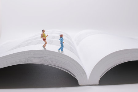 a fun of mini people running on the bookの写真素材