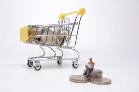 a figure businessman sitting on stacked coinの写真素材