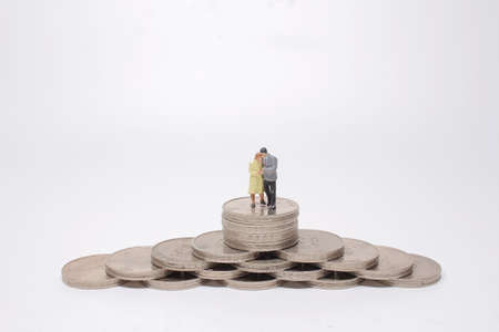 a Mini people: couple standing on stacking coins