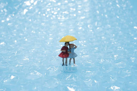 the mini figure walk ubder the rain with umbrellaの写真素材