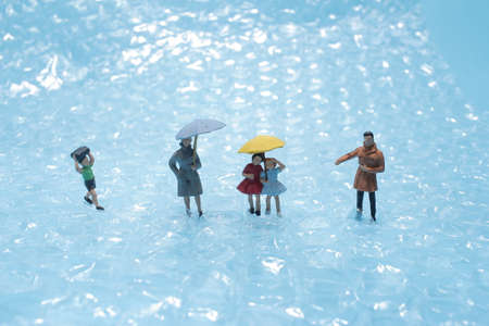 the mini figure walk ubder the rain with umbrellaの写真素材