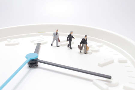 a mini figure hurry up to transport on clockの写真素材