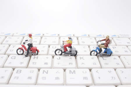 the mini figure with motobike on the keyboardの写真素材