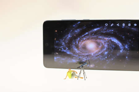 mini figure of Astronomer with a telescope watching the stars