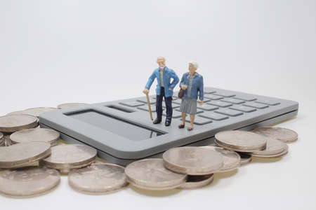 Life insurance concept. old couple figure standing Calculatorの写真素材