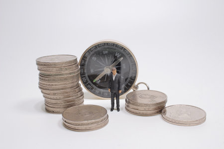 the mini business figure with the pile coins and compassの写真素材