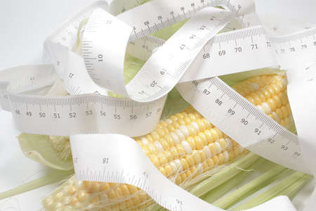Fresh Corn and Measuring Tape on white Background.の写真素材