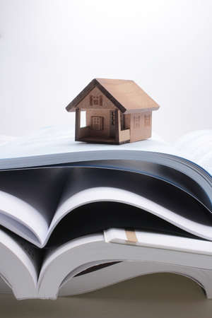 Book stacking. Open book, hardback books on wooden houseの写真素材