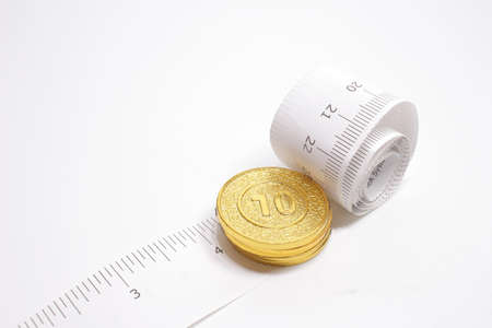 the Coins And Tape Measure on the white back groundの写真素材