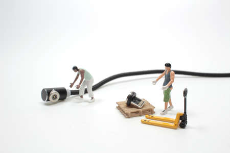 Miniature worker moving USB cable on white background, technology worker