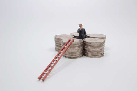 the Investment mini business man surrounded by coinsの写真素材