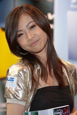 young hostesses stand next to products at the exhibition. 25 Aug 2007のeditorial素材