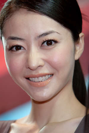 young hostesses stand next to products at the exhibition. 25 Aug 2007のeditorial素材